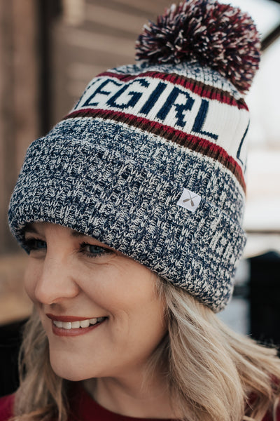 Person wearing a 'LAKEGIRL' beanie with a blurred background